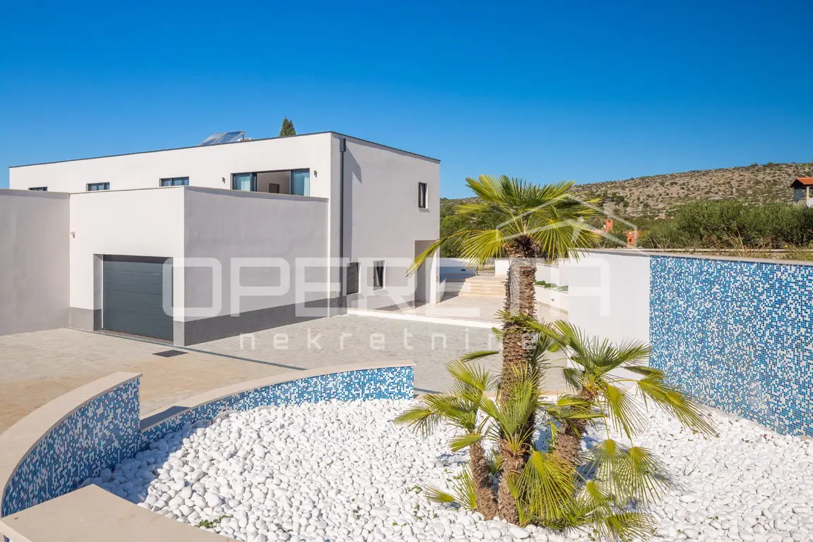 Poolbereich mit Mosaik, Palmen und weißem Kies