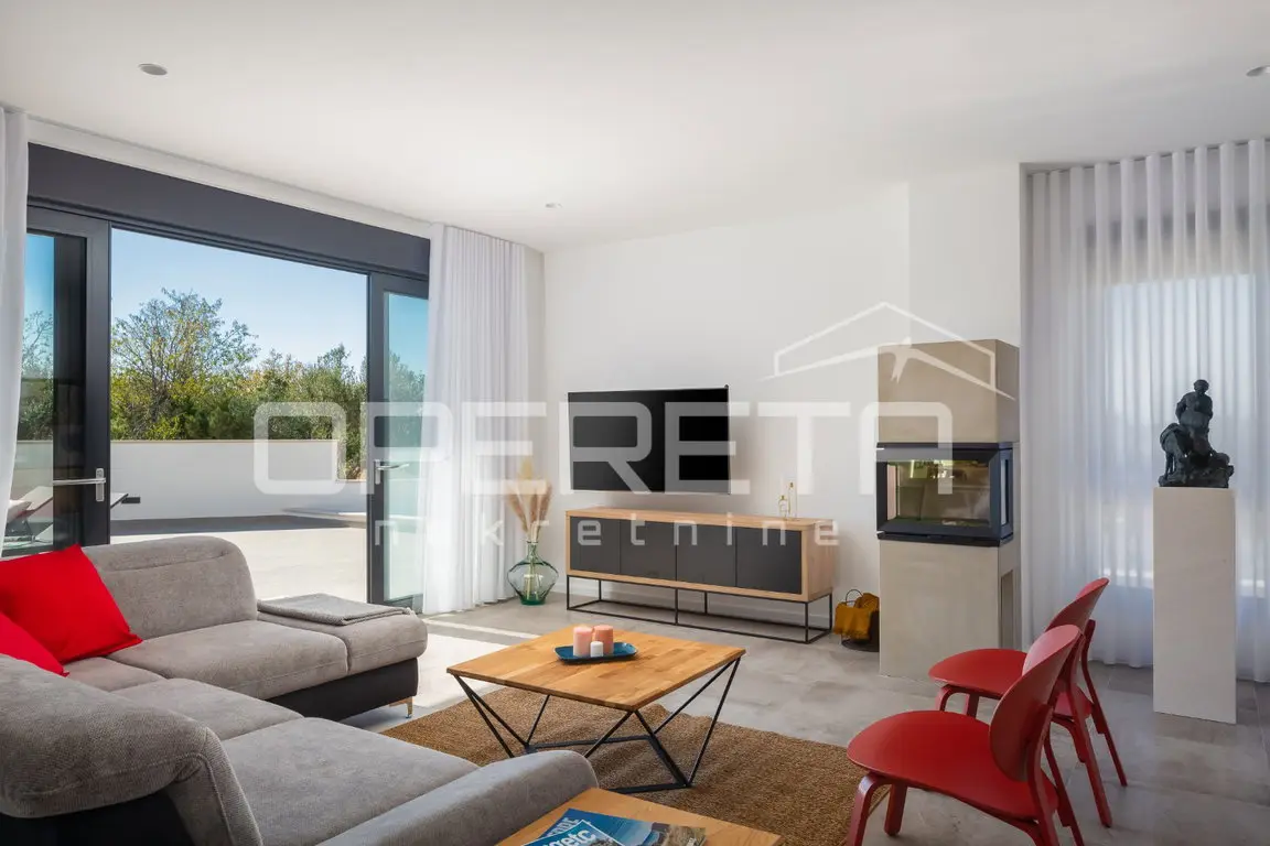 Wohnzimmer mit Sofa, roten Stühlen und Kamin