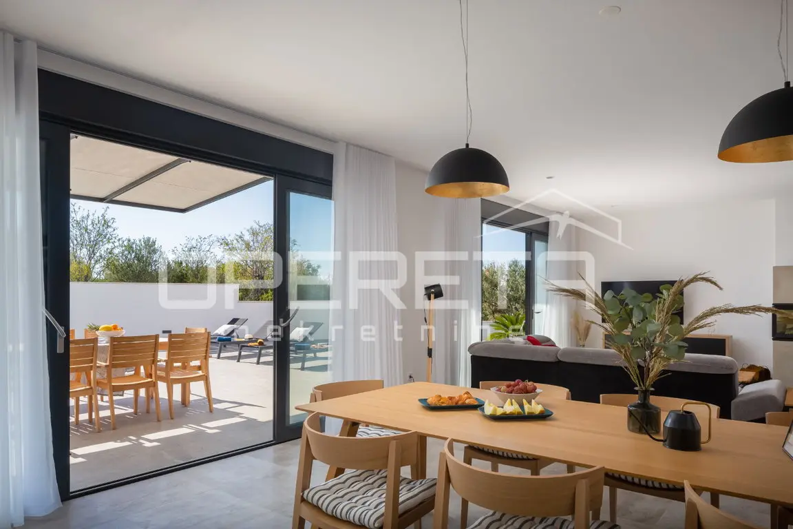 Essbereich mit Holztisch und Glasfront zur Terrasse