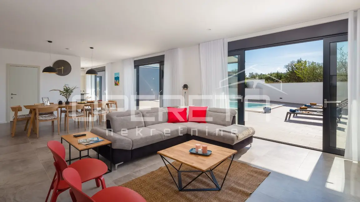 Offener Wohnbereich mit Sitzecke und Blick zum Pool