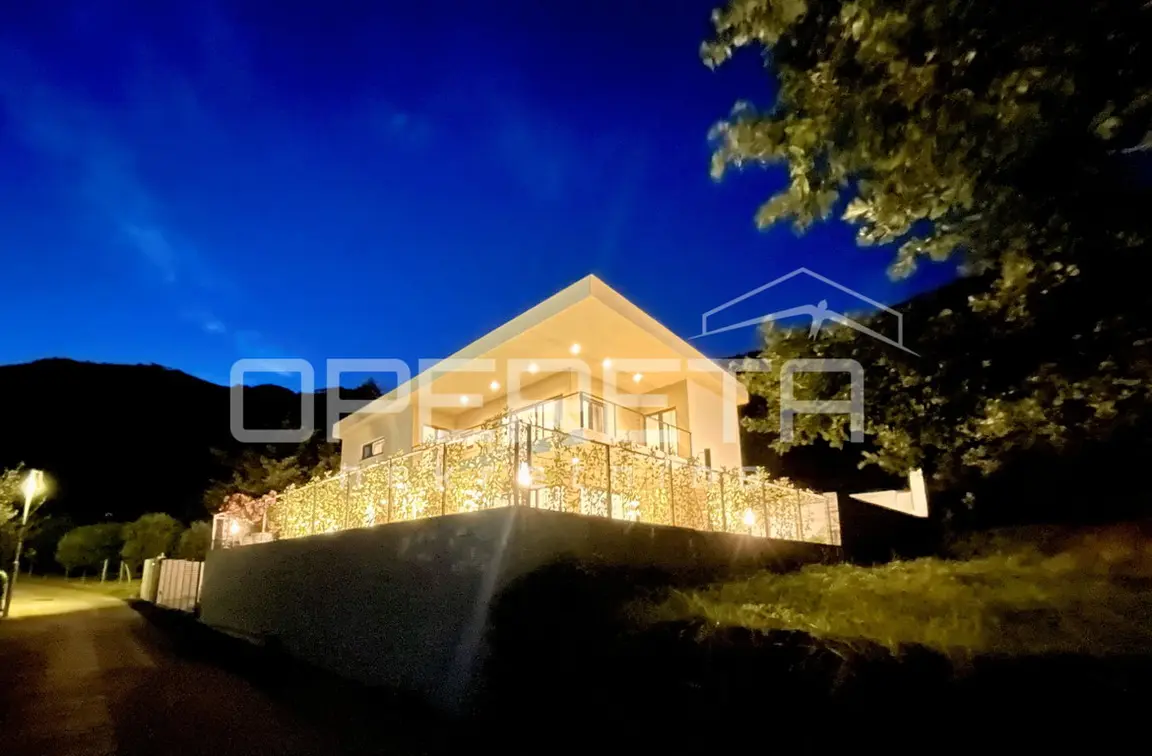 Die beleuchtete Villa am Hang bei Nacht