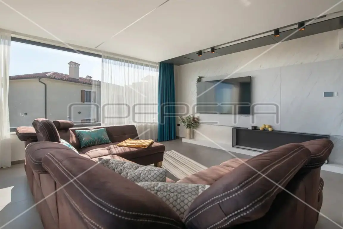 Wohnzimmer mit großem Ecksofa und Fensterfront